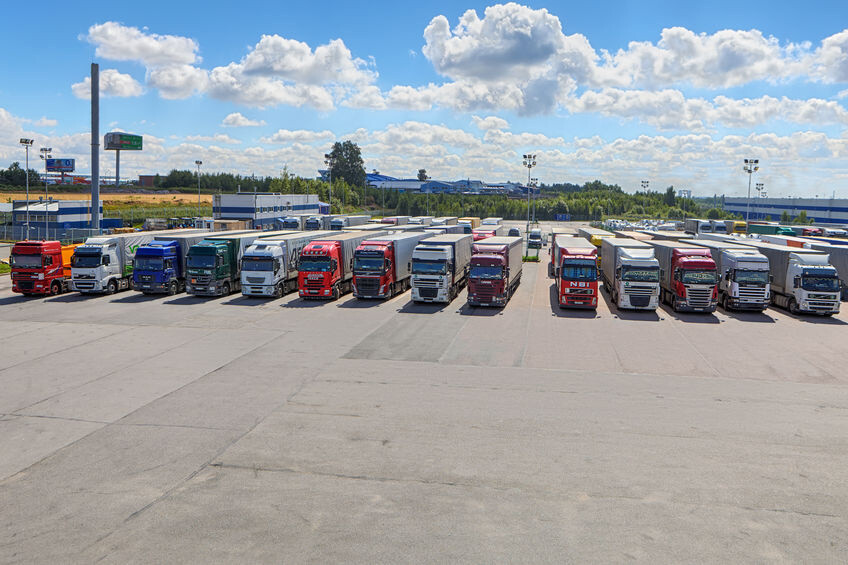 Poids lourds de différentes marques alignés sur un parking