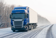 Camion bleu sur route enneigée