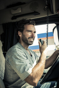 Chauffeur heureux dans la cabine de son camion de transport de marchandises