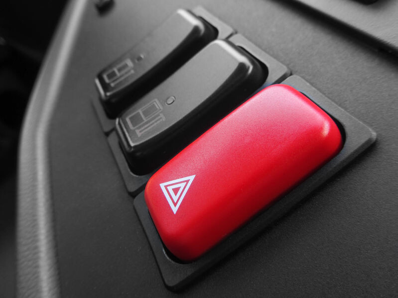 Focus over a red emergency triangle button inside a bus