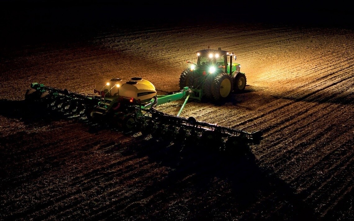 TRacteur équipé de pneus agricoles Michelin labourant un champ de nuit