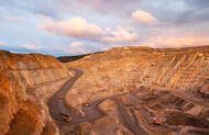 A top view of a mining quarry with multiple mining vehicles at work.