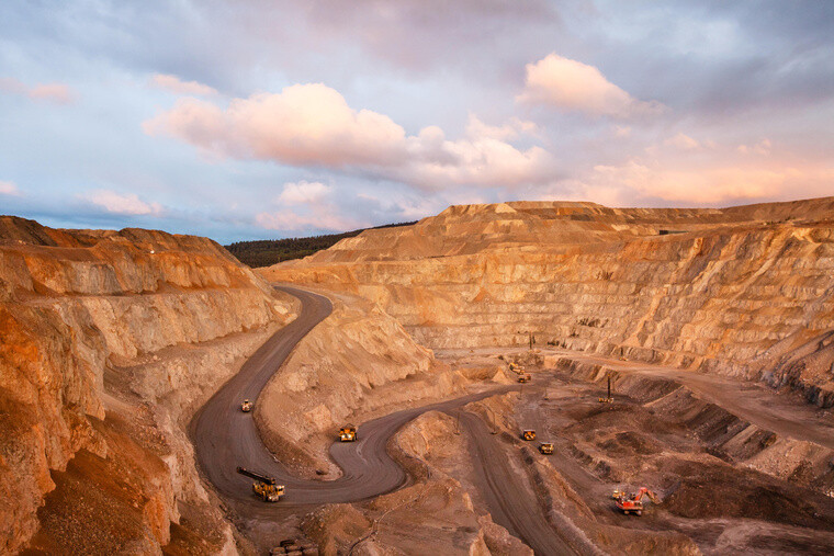 A top view of a mining quarry with multiple mining vehicles at work.