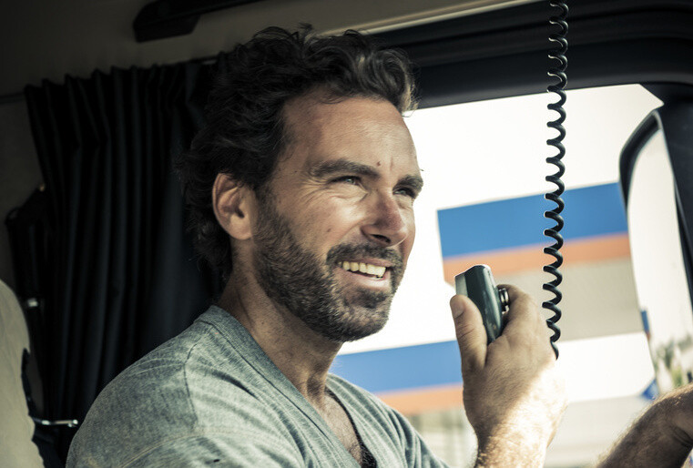 Happy driver in his truck cab Freight transport