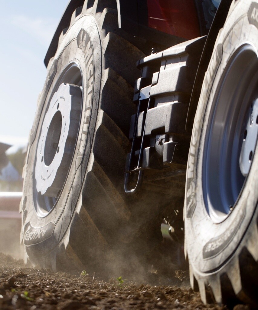 Close-up of large agricultural tractor equipped with Michelin Axiobib 2 tires operating on cultivated soil.