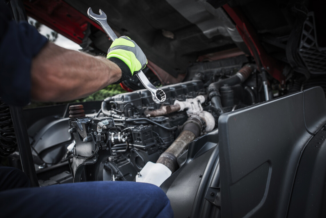 Caucasian Truck Mechanic Repairing Semi Truck Engine.