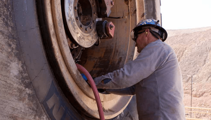 Miner inflating rigid dump truck tyre
