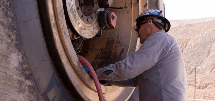 Miner inflating rigid dump truck tyre