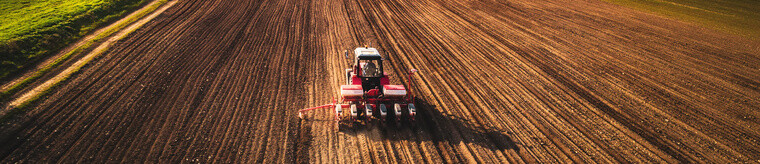 Farmer in tractor preparing farmland with seedbed for the next year