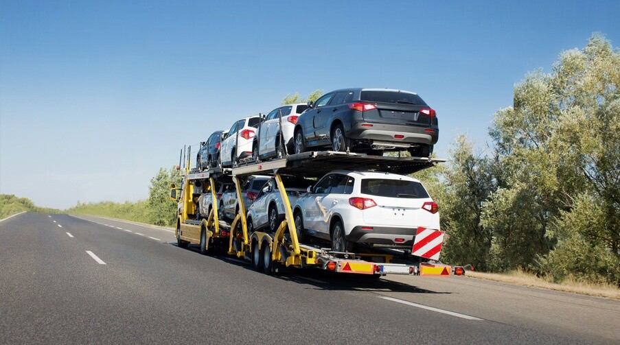Big car carrier trailer with new cars for sale on bunk platform. Car transport truck on the highway; Shutterstock ID 1024882123