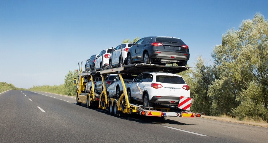 Big car carrier trailer with new cars for sale on bunk platform. Car transport truck on the highway; Shutterstock ID 1024882123