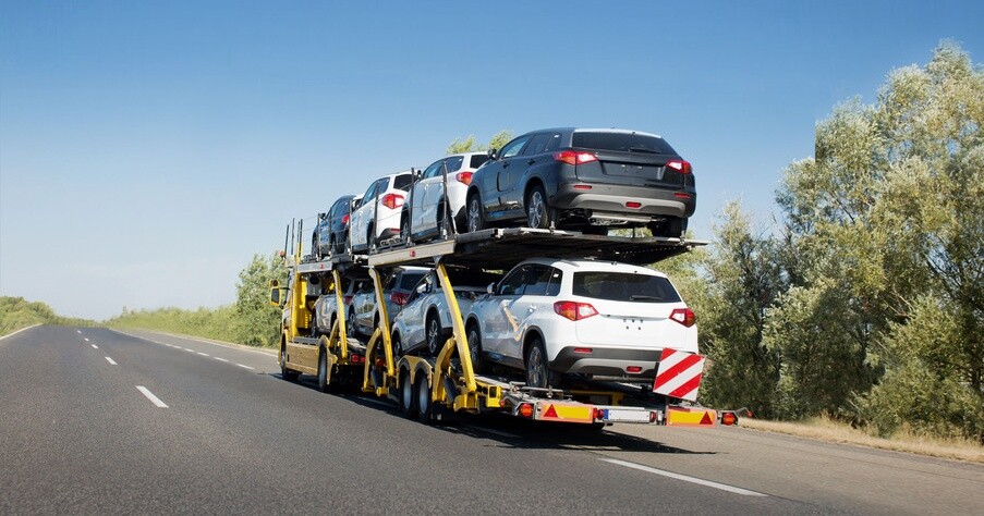 Big car carrier trailer with new cars for sale on bunk platform. Car transport truck on the highway; Shutterstock ID 1024882123