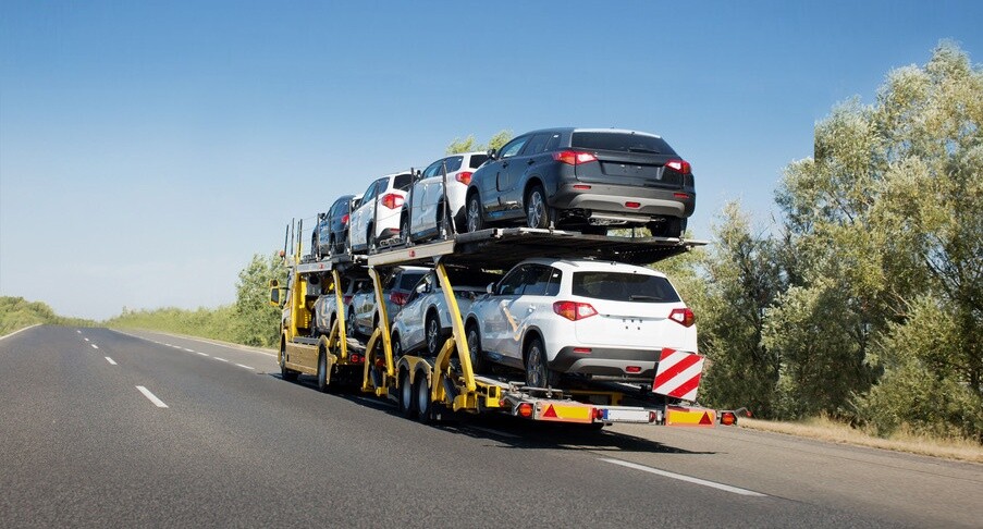 Big car carrier trailer with new cars for sale on bunk platform. Car transport truck on the highway; Shutterstock ID 1024882123