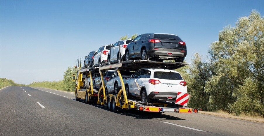 Big car carrier trailer with new cars for sale on bunk platform. Car transport truck on the highway; Shutterstock ID 1024882123