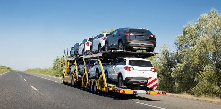 Big car carrier trailer with new cars for sale on bunk platform. Car transport truck on the highway; Shutterstock ID 1024882123
