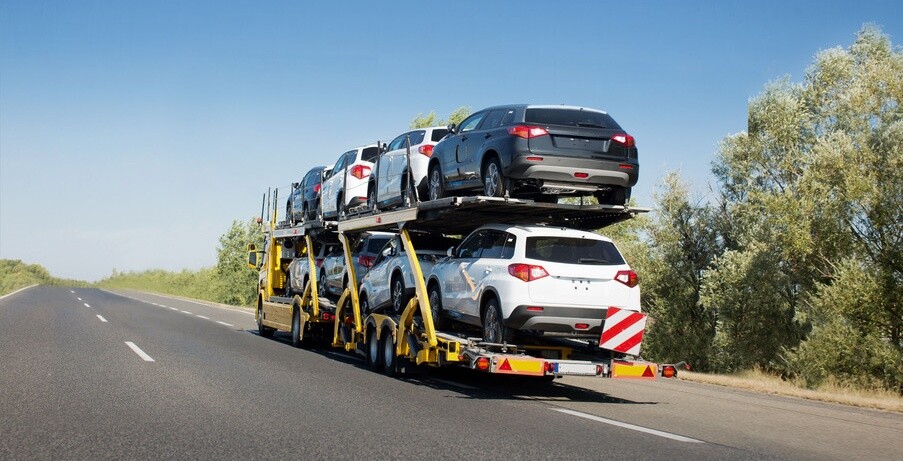 Big car carrier trailer with new cars for sale on bunk platform. Car transport truck on the highway; Shutterstock ID 1024882123