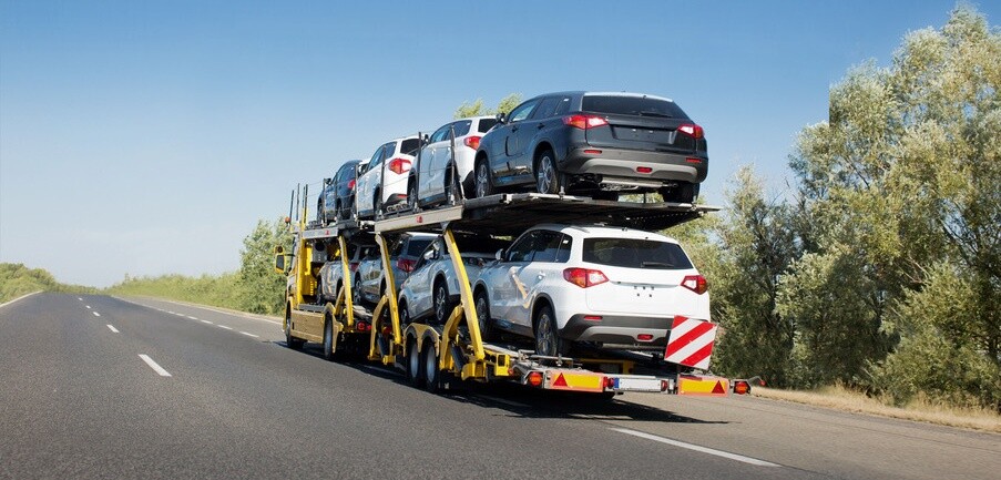 Big car carrier trailer with new cars for sale on bunk platform. Car transport truck on the highway; Shutterstock ID 1024882123