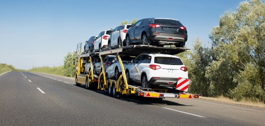 Big car carrier trailer with new cars for sale on bunk platform. Car transport truck on the highway; Shutterstock ID 1024882123