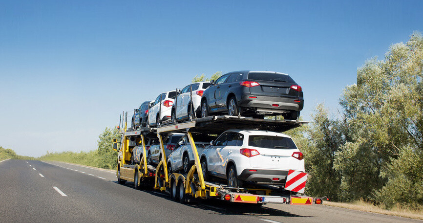 Big car carrier trailer with new cars for sale on bunk platform. Car transport truck on the highway; Shutterstock ID 1024882123