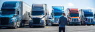 man inspecting semi trucks