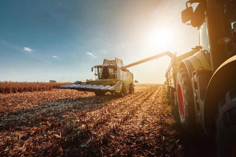 Sklízecí stroj a traktor na poli