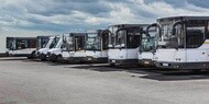 Fleet of commercial buses parked at a service facility
