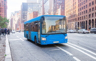 Blue transit bus stopped on city street