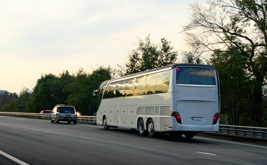 Charter bus driving on highway with trees