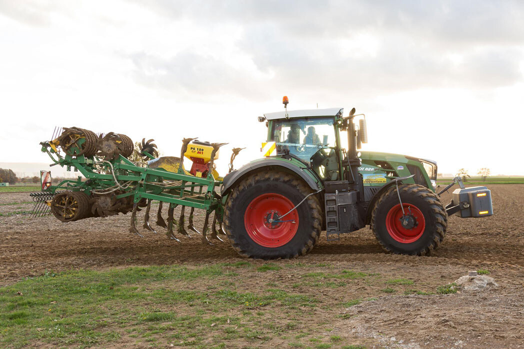 Tractor with implement driving through field