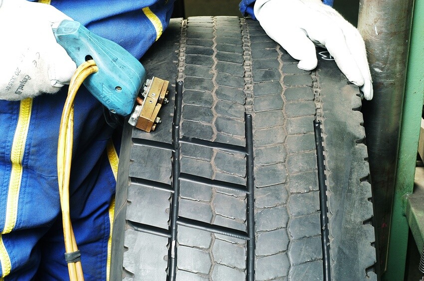 A tyre being regrooved in the factory