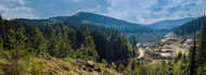 Landscape of the planet featuring mountains in the background and a dirt mining road