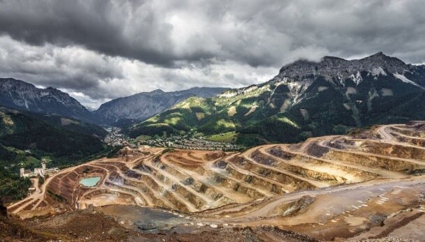 mining road leading to quarry with clouds and mountains in background