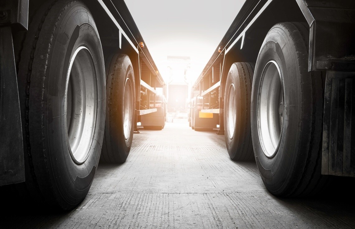 looking at tire-level down the row between two parked semi truck trailers