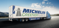 Semi truck with a blue cab and Michelin GreenerFleets written on the side of the trailer with a blue wind skirt