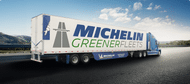 Semi-camion avec une cabine bleue et indiquant GreenerFleets de Michelin écrit sur le côté de la remorque avec une jupe latérale bleue