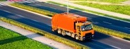 Garbage truck driving down road