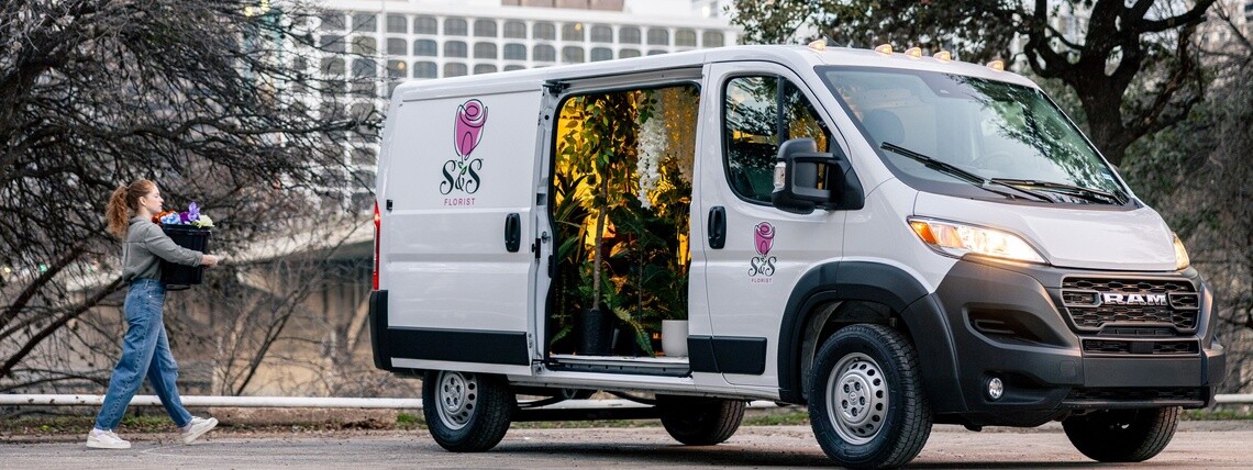 Florist loading up a white commercial van that is equipped with Michelin Agilis tires