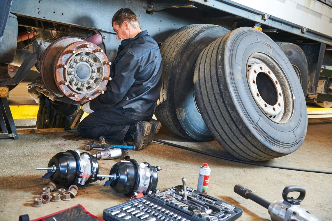 Technician doing maintenance on a wheel with the tire set to the side