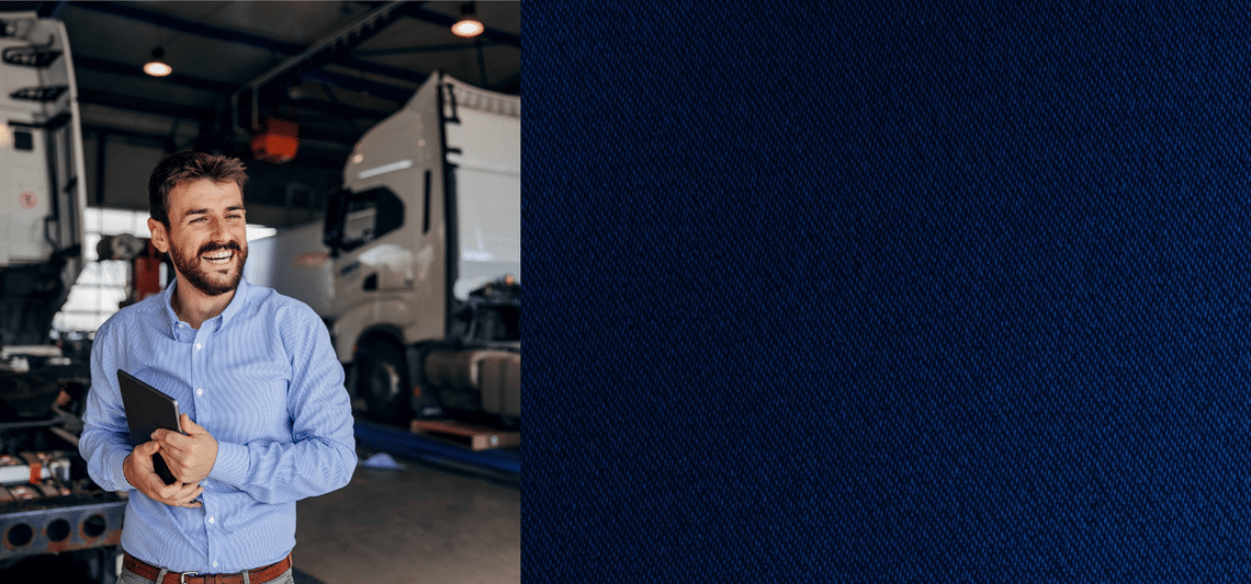 Split image with blue texture on right and a man in blue button down shirt standing in front of semi trucks on the left