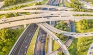 An aerial view of criss-crossing highways with overchanges and green grass medians