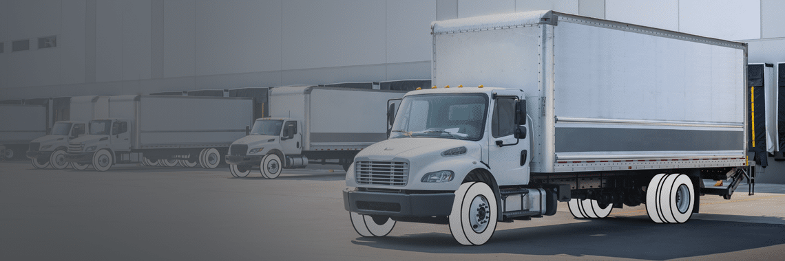 Gray gradient turning into white box truck on right that has white overlay for tires