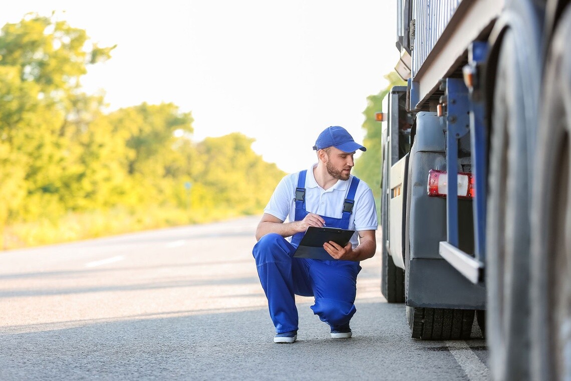 トラックタイヤを点検する作業員