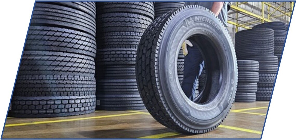 person rolling a retreaded Michelin casing through a warehouse