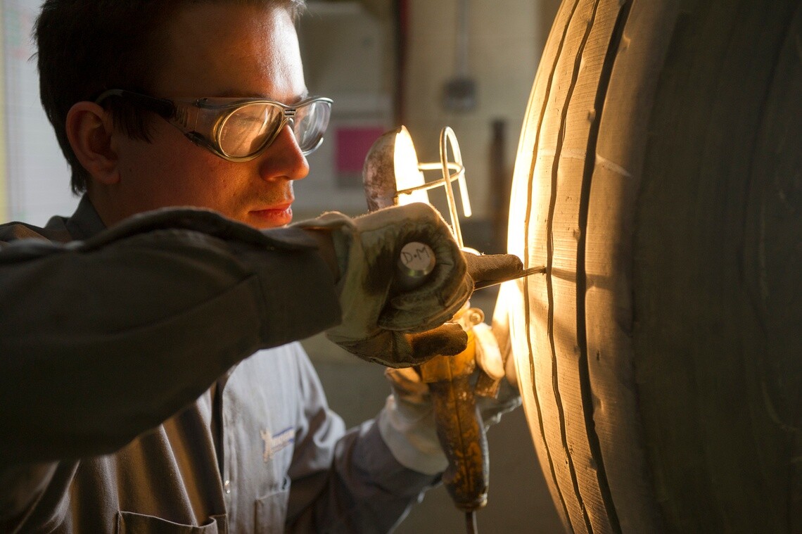 Technician repairing a heavy goods vehicle tire before truck tyre retreading
