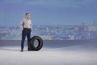 Head of transport department standing next to a MICHELIN AGILIS CROSSCLIMATE tire with city backdrop