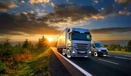 truck and van in motion on a highway at sunset