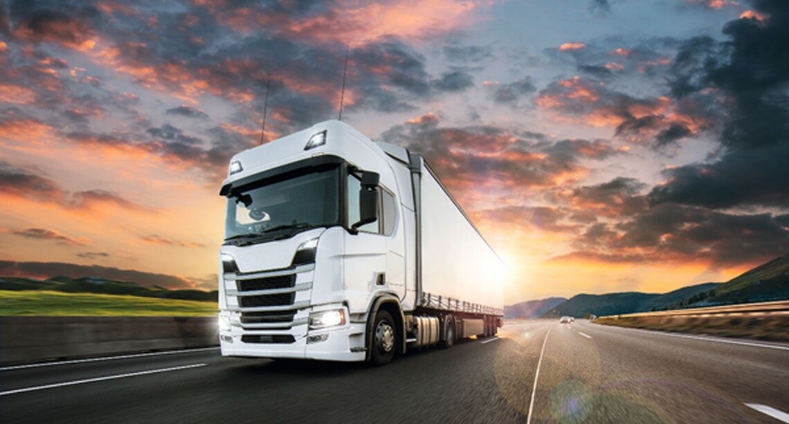 Truck with container on a highway at sunset