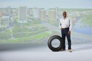 Vice President of Fleet service next to a MICHELIN AGILIS CROSSCLIMATE tire with city backdrop