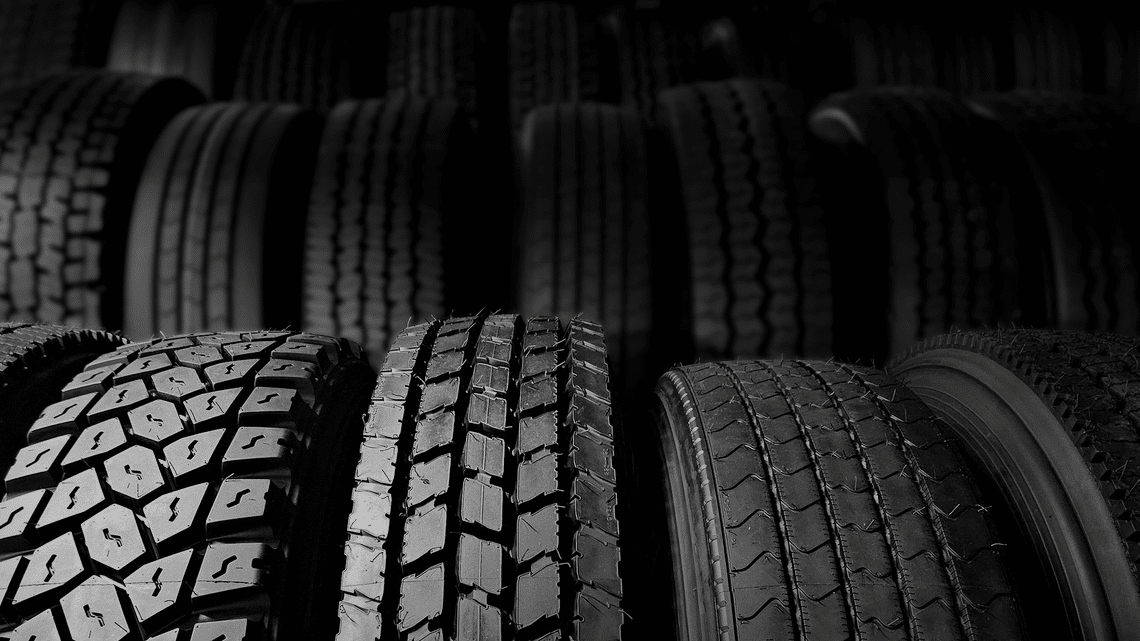Rows of tires lined up showing the different tread patterns of the retreads