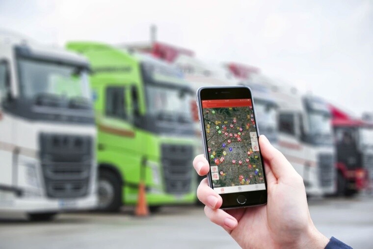 Smartphone showing the driver recruitment and navigation application for freight transport  app in a lorry park